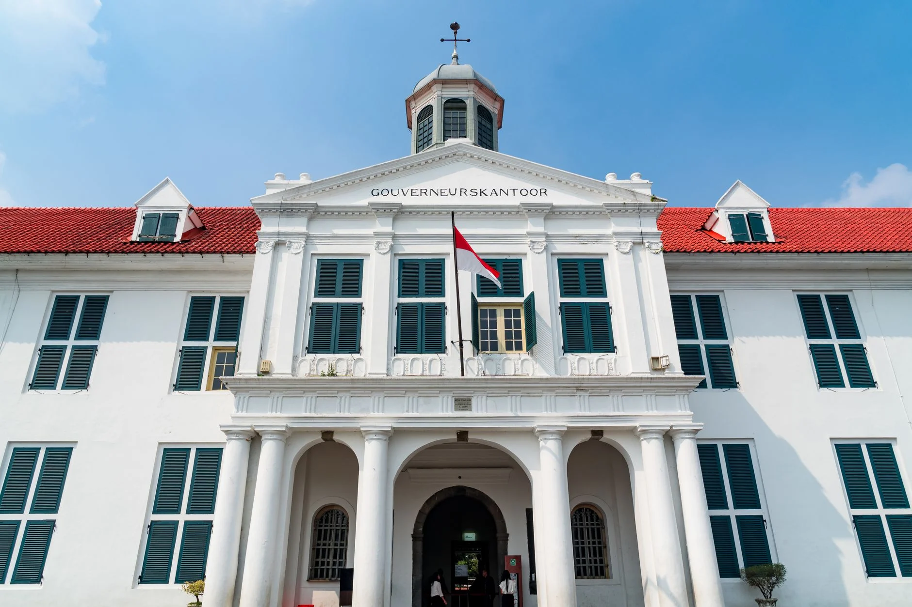 Gambaran rumah pemerintahan modern dengan arsitektur tradisional, menonjolkan elemen budaya Indonesia